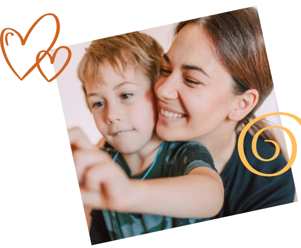 A Spark therapist smiling warmly with a young boy during a session