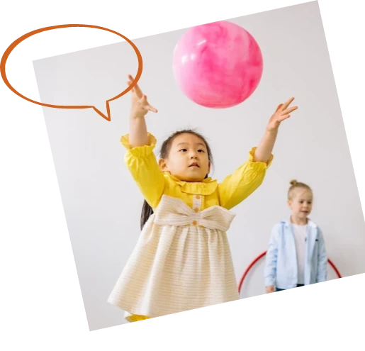 A young child joyfully tossing a ball during a play-based therapy session